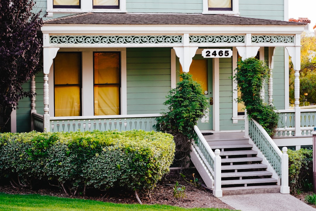 The bright, sunny exterior of a modern craftsman-style home with a welcoming porch, representing a valuable Atlanta real estate asset.