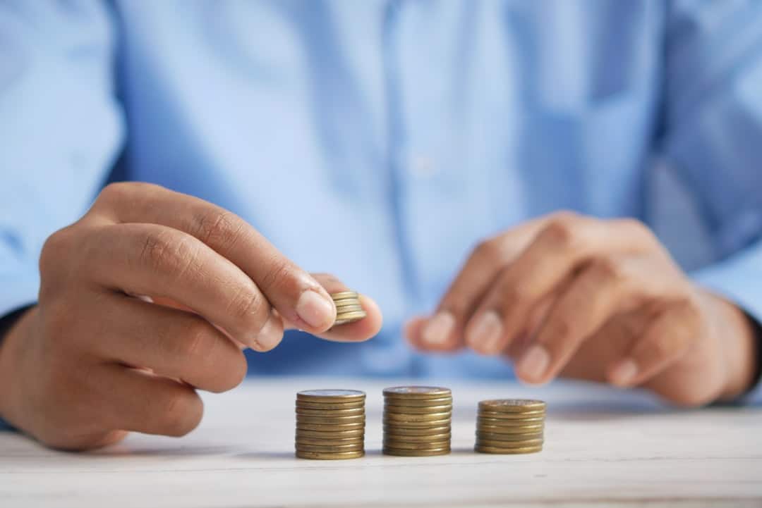 A close-up shot of hands professionally splitting a stack of cash on a table, illustrating the division of money for real estate commissions.