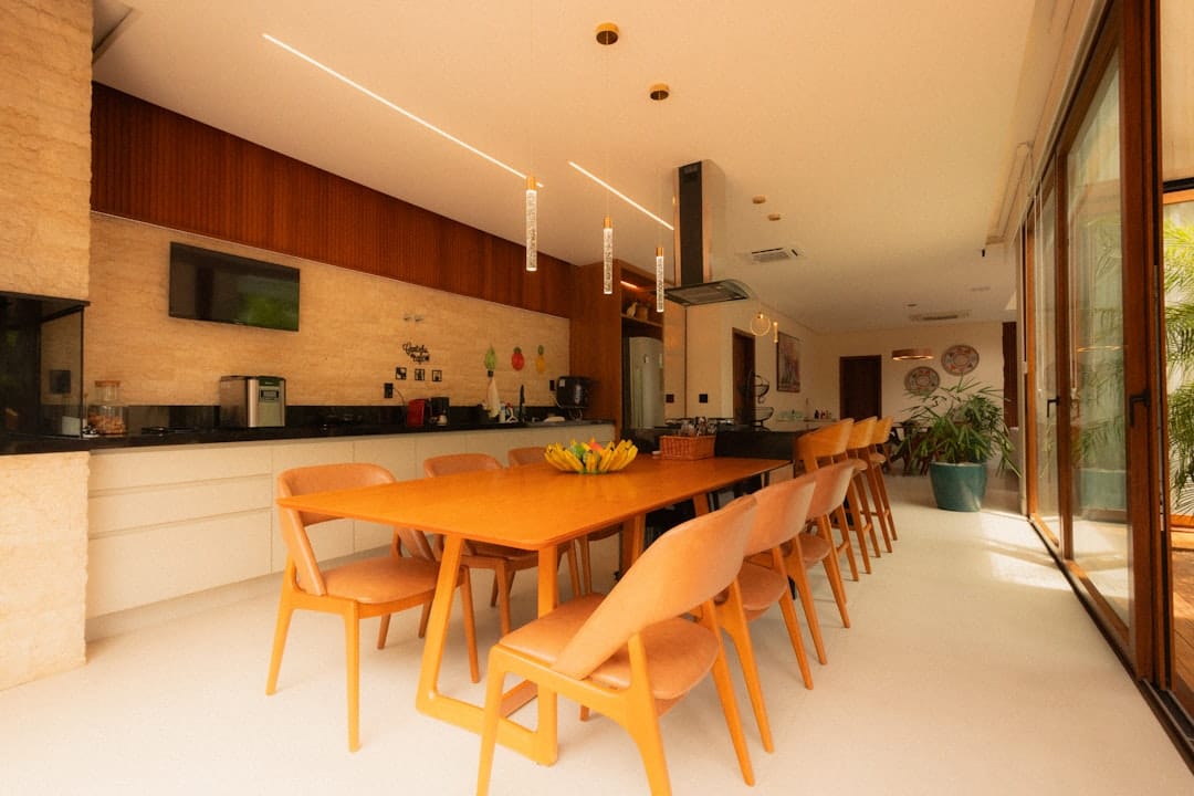 A professional and friendly real estate agent sits with a couple at a dining table, explaining documents and showcasing the full-service aspect of their commission model.