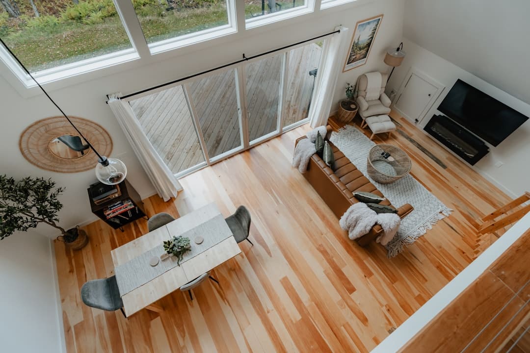 A family joyfully unpacking moving boxes in the spacious, sunlit living room of their new home, illustrating the reward of a smart financial move.
