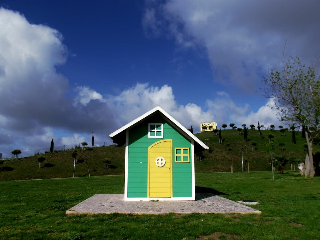 A minimalist, house-shaped piggy bank on a bright, clean background, representing the concept of saving money and protecting equity when selling a home.