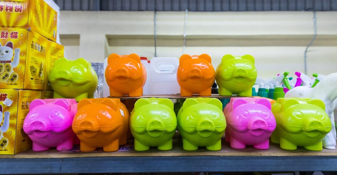 Person's hand places a coin into a minimalist, house-shaped piggy bank, symbolizing the financial savings of a 1% real est...