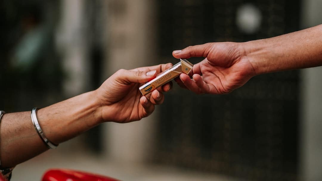A close-up, modern shot of two people's hands exchanging house keys, signifying a successful and profitable home sale.