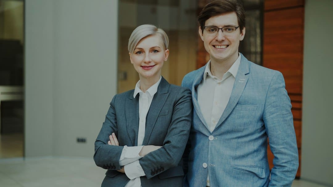 A professional real estate agent in a modern home, smiling and shaking hands with a client, representing a successful and transparent property sale.