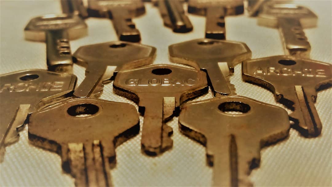 A set of modern house keys resting next to a full piggy bank on a clean, bright surface, symbolizing the savings and equity retained when selling a home.